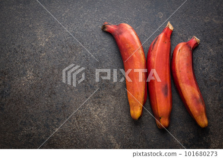 Tasty red bananas on black table. Top view. Tasty red bananas on black table. Top view. 101680273