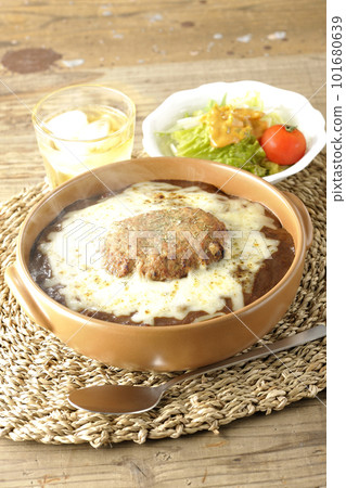 Piping hot curry and salad topped with plenty of cheese and hamburger 101680639
