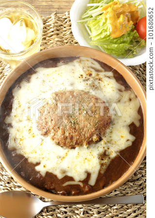 Piping hot curry and salad topped with plenty of cheese and hamburger 101680652