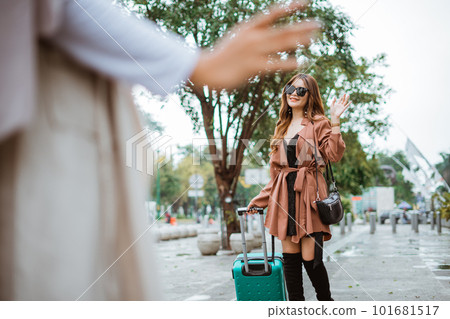 traveller with long brown hair bring the trunk and waving her hand traveller with long brown hair bring the trunk and waving her hand 101681517