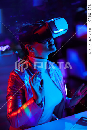 smiling stylish woman exploring metaverse in modern office 101681998