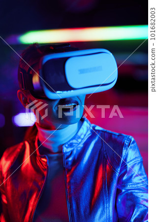 smiling stylish woman in vr headset on dark background 101682003