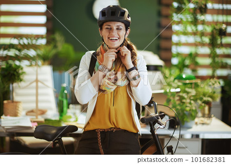smiling elegant business woman in bike helmet in eco office 101682381