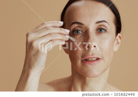 modern woman with cosmetic elixir against beige background 101682449