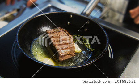 The cook fries pork meat on pan with rosemary 101682531