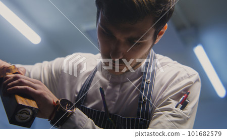 Male cook adds spices using spice grinder Male cook adds spices using spice grinder 101682579