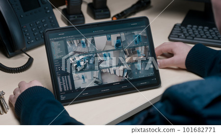 Security officer controls CCTV cameras in office 101682771
