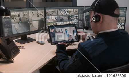 Security officer controls CCTV cameras 101682808