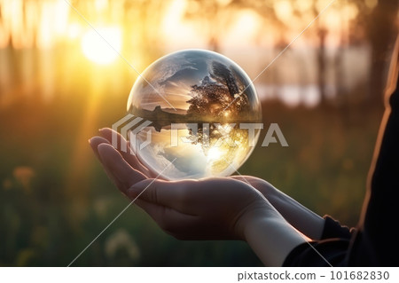 Woman's hand holding a crystal ball reflecting nature 101682830