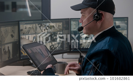 Security officer controls CCTV cameras 101682861