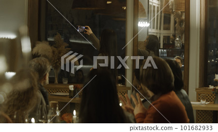 Asian woman takes photo of friends in cafe Asian woman takes photo of friends in cafe 101682933
