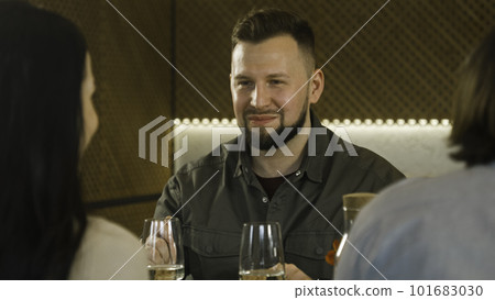 Man eats and talks with friends in cafe 101683030