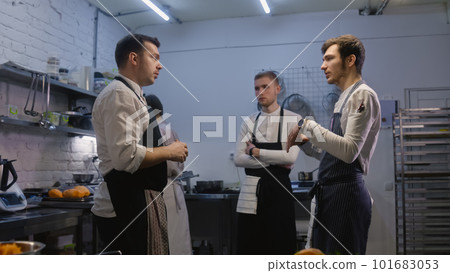 Adult chef stands with colleagues and discussing menu 101683053
