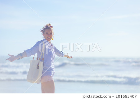 smiling stylish woman rejoicing at beach 101683407