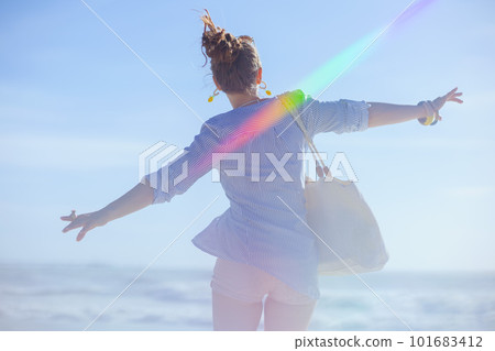 Seen from behind woman rejoicing at beach 101683412