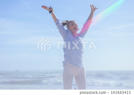 smiling elegant female at beach rejoicing and jumping smiling elegant female at beach rejoicing and jumping 101683415