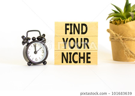 Find your niche symbol. Concept words Find your niche on wooden blocks. Black alarm clock. Beautiful white table white background. Business and find your niche concept. Copy space. 101683639