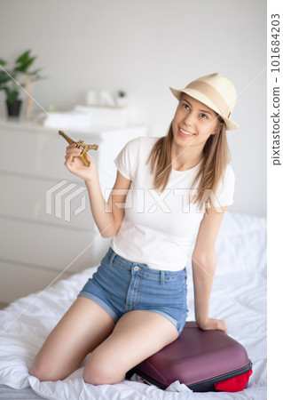 Portrait of positive young woman with packed baggage and notes 101684203