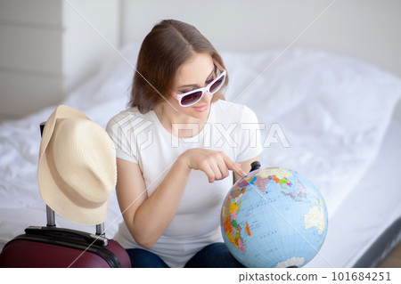 Attractive girl sitting on sofa and packing luggage Attractive girl sitting on sofa and packing luggage 101684251