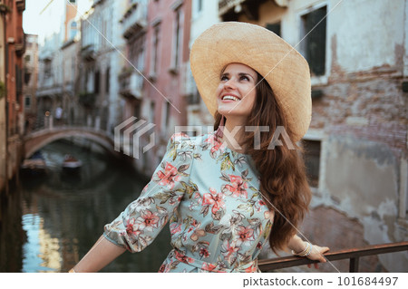 smiling young tourist woman in floral dress enjoying promenade smiling young tourist woman in floral dress enjoying promenade 101684497