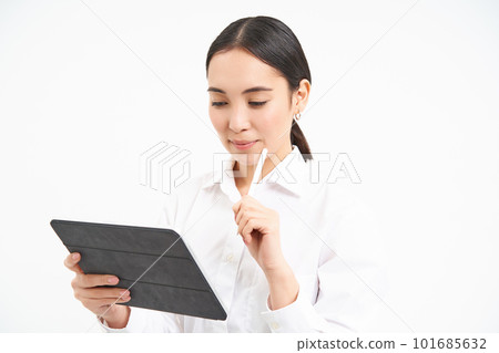 Corporate asian woman, manager using digital tablet, working on gadget, checking charts, company statistics, standing over white background 101685632