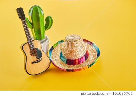 Cinco de Mayo holiday background. Cactus, guitar and hat on yellow background. Cinco de Mayo holiday background. Cactus, guitar and hat on yellow background. 101685705