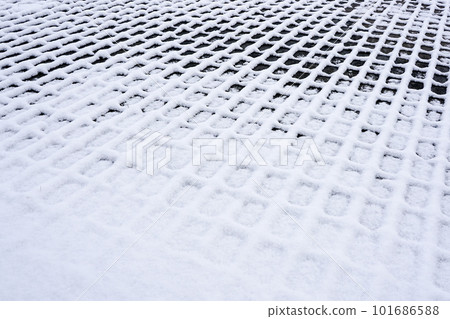 A checkered outline snowy pattern on dark cobblestones, perspective view on snow texture A checkered outline snowy pattern on dark cobblestones, perspective view on snow texture 101686588