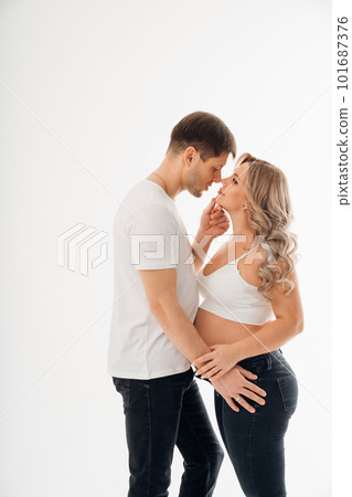 a couple waiting for a child in white T-shirts and jeans on a white background. 101687376