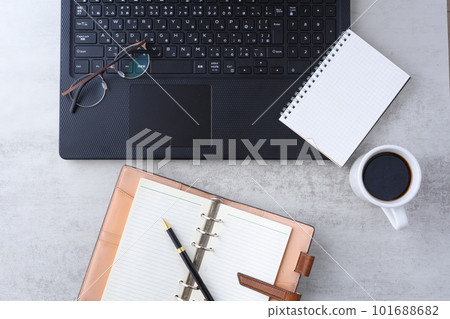 將膝上型電腦和筆記本放在桌子上，一邊喝咖啡一邊做案頭工作的圖片 101688682