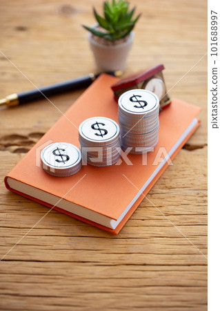 Money (dollars) piled up on a book Money (dollars) piled up on a book 101688997
