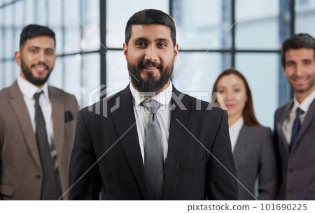portrait shot of smiling business team of four standing and smiling at camera against a modern office background portrait shot of smiling business team of four standing and smiling at camera against a modern office background 101690225