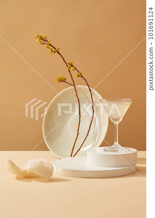 White podiums with a glass of bird nest soup on top decorated with a branch of yellow flowers and edible bird nests. Bird nest brings a lot of benefits to the brain, health and skin 101691124