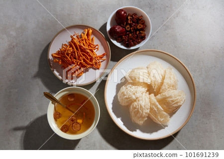 Flat lay of bird nest soup, jujube inside a bowl, a dish of edible bird nest and cordyceps. Bird nest and herbs are well-known in Korea and China as a traditional medicine 101691239