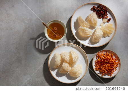 A dish of edible bird nest and jujube decorated with cordyceps and a ceramic bowl containing bird nest soup. Copy space. Healthcare concept 101691240