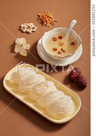 Advertising photo with bird nest, jujube, rock sugar, lotus seeds and Cordyceps on brown background. Herbs from nature, good for health, precious and expensive. 101691255