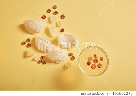 The bird nest dish gives a sweet taste with jujube, rock sugar and edible bird nest on yellow background. Healthcare food, anti-aging, strengthen the immune system The bird nest dish gives a sweet taste with jujube, rock sugar and edible bird nest on yellow background. Healthcare food, anti-aging, strengthen the immune system 101691273