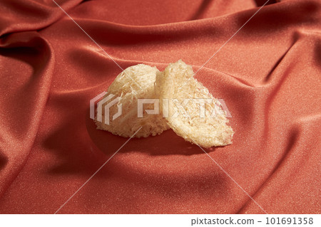 Some edible bird nest are arranged on top of a luxurious pink fabric background. Close-up view. Bird nest brings a lot of nutritional value for people Some edible bird nest are arranged on top of a luxurious pink fabric background. Close-up view. Bird nest brings a lot of nutritional value for people 101691358