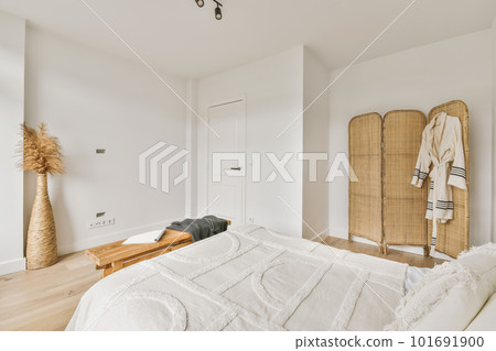 a bedroom with white walls and wood flooring on the wall, there is a large bed in the room a bedroom with white walls and wood flooring on the wall, there is a large bed in the room 101691900
