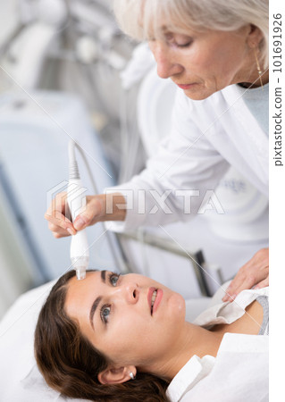 Young woman having face vacuum cleaning procedure Young woman having face vacuum cleaning procedure 101691926