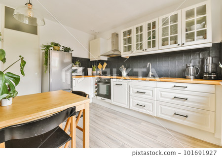 a kitchen with white cabinets and wood counter tops on the island in front of the sink is wooden flooring 101691927