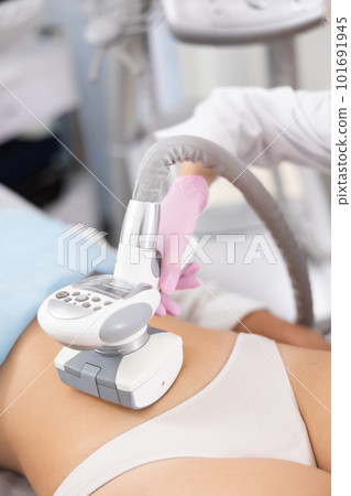 LPG massage device applied on young woman's belly 101691945