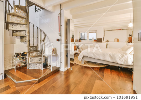 a bedroom with wood flooring and a staircase leading up to a bed in the room is very white color 101691951