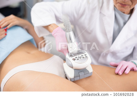 Faceless doctor doing Rf lifting procedure on... - Stock Photo