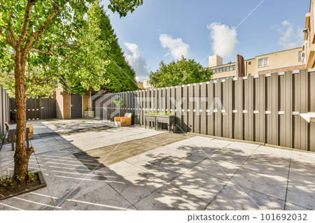 a fenced area with trees and buildings in the background on a sunny day at an urban townhome a fenced area with trees and buildings in the background on a sunny day at an urban townhome 101692032
