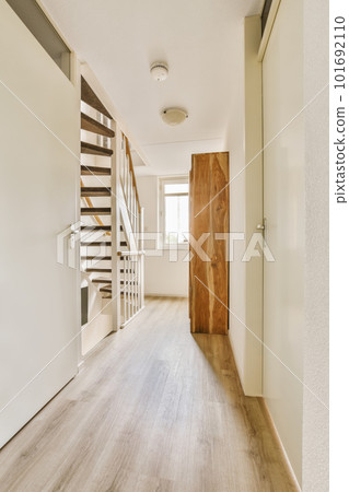 an empty room with wood flooring and wooden staircase leading up to the second floor in a white wall is on the right side an empty room with wood flooring and wooden staircase leading up to the second floor in a white wall is on the right side 101692110