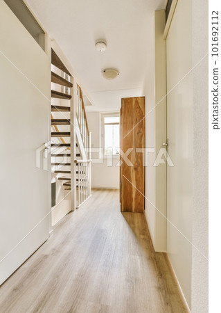 an empty room with wood flooring and wooden staircase leading up to the second floor in a white wall is on the right side an empty room with wood flooring and wooden staircase leading up to the second floor in a white wall is on the right side 101692112