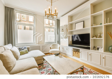 a living room with two couches and a large flat screen tv on the wall in front of the window 101692176