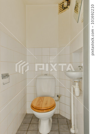 Flush toilet located between sink in small tiled bathroom of contemporary apartment Flush toilet located between sink in small tiled bathroom of contemporary apartment 101692210