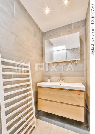 a modern bathroom with grey tiles and white fixtures on the walls, along with a towel rack in the corner 101692280