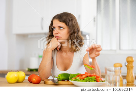 Portrait of sad woman eating salad at home Portrait of sad woman eating salad at home 101692314